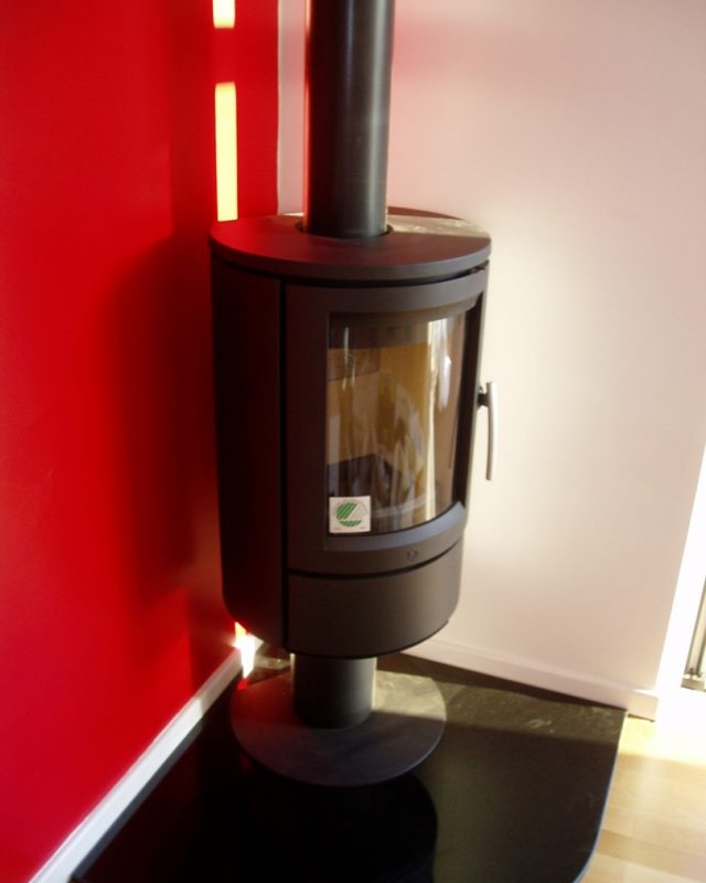 log burning stove on red wall